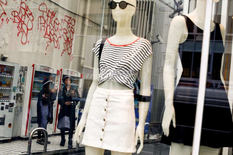 FILE PHOTO: People stand next to fashion boutique in a shopping district in Tokyo