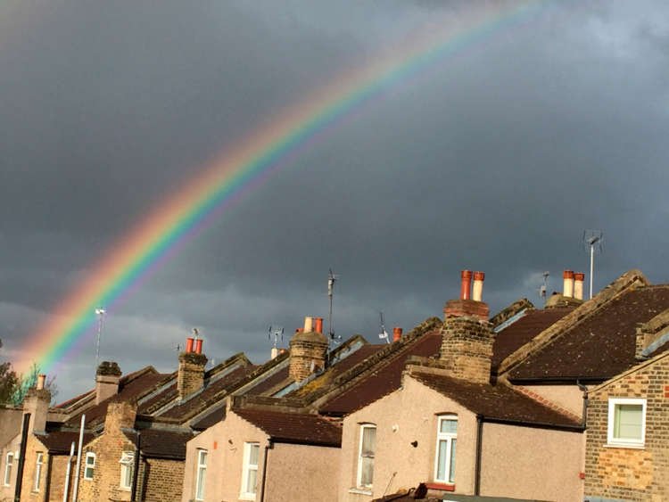 FILE PHOTO: A rainbow forms over terraced housing during a rain storm in south London