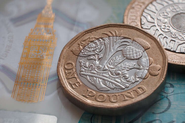 British one pound coin and polymer 5 pound banknote symbolizing UK currency volatility - Global Banking & Finance Review