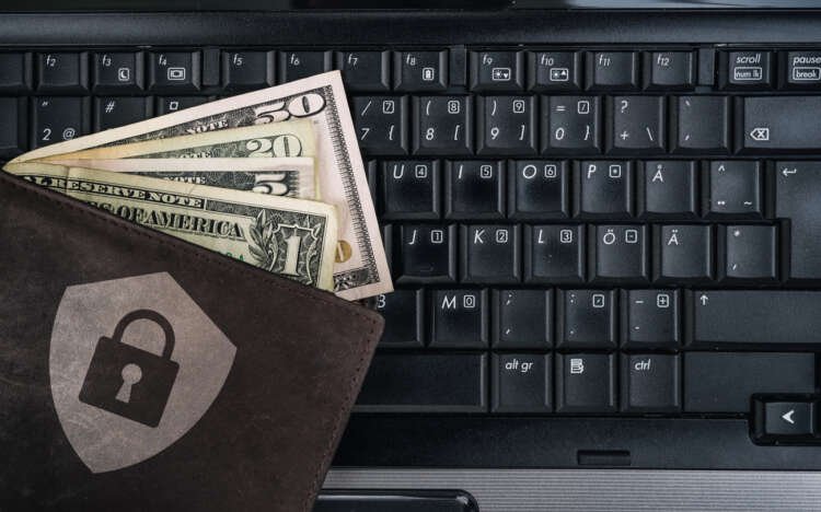 Digital banking security concept with a wallet and US dollars on a laptop - Global Banking & Finance Review