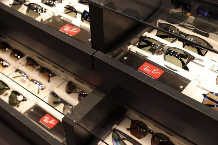 Ray-Ban and Oakley sunglasses displayed in a retail store, showcasing luxury eyewear by EssilorLuxottica - Global Banking & Finance Review