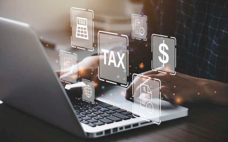 Business owner using a laptop for digital tax preparation under MTD - Global Banking & Finance Review
