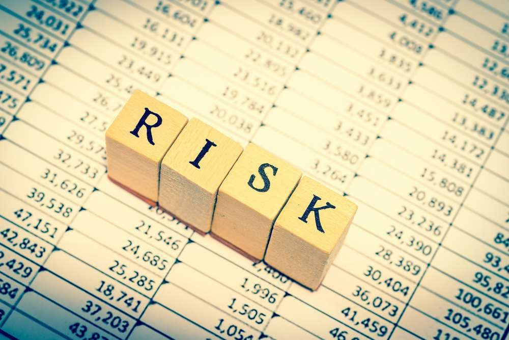 A financial professional analyzing spreadsheet data, highlighting risks - Global Banking & Finance Review