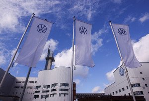 Volkswagen logo with a backdrop of economic graphs and tariffs - Global Banking & Finance Review