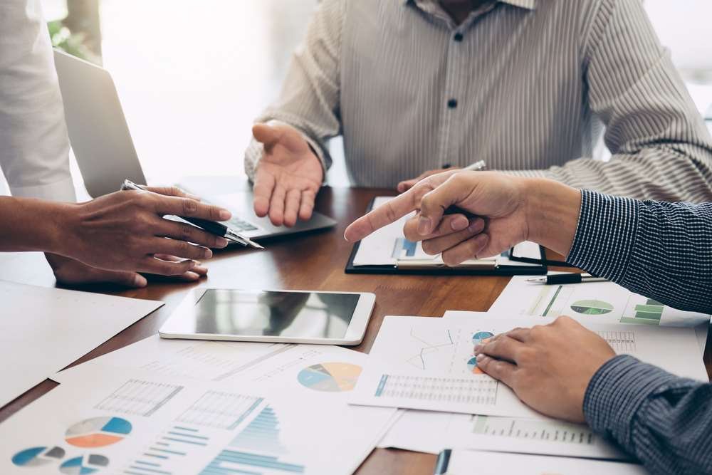 Business professionals analyzing financial reports for increased investor due diligence - Global Banking & Finance Review