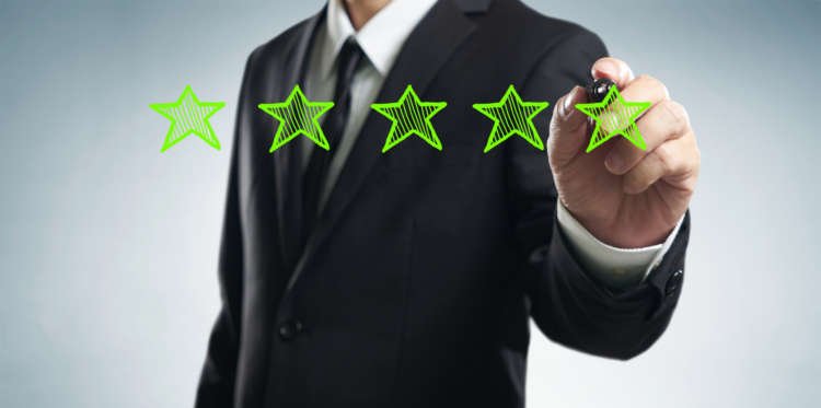 Businessman illustrating performance increase with five green stars - Global Banking & Finance Review