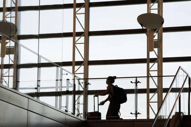 Passengers traveling without masks at an airport during COVID-19 policy changes - Global Banking & Finance Review