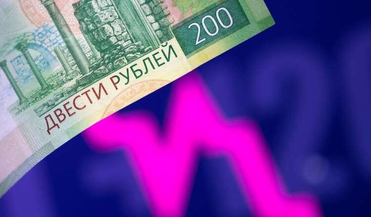 FILE PHOTO: Illustration shows a Russian rouble banknote and a descending stock graph