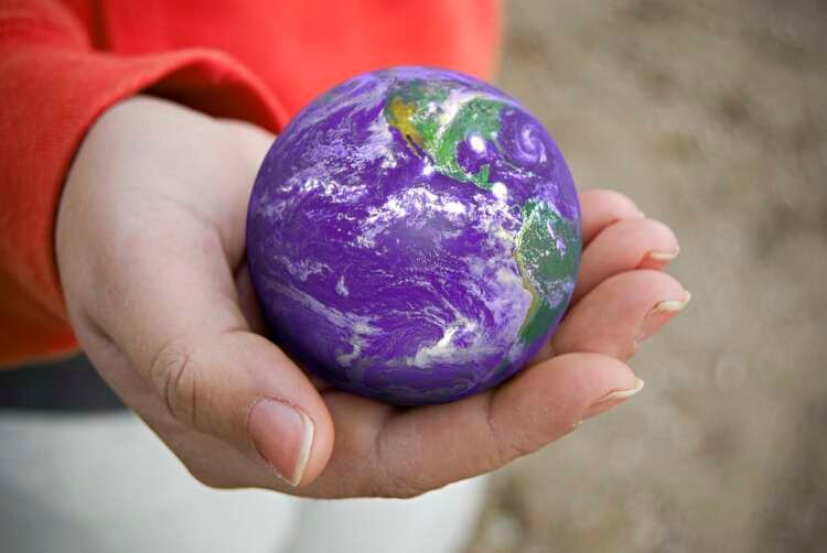 A person holding the Earth in their palm, symbolizing the importance of ESG data - Global Banking & Finance Review