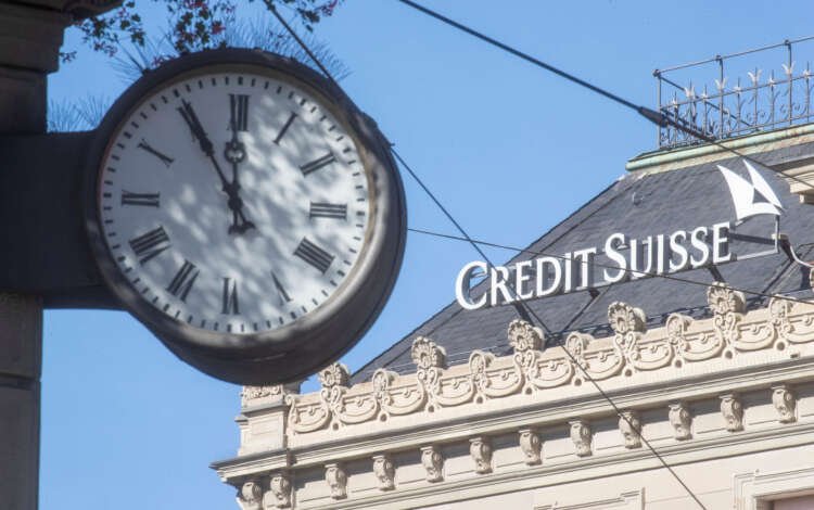 Credit Suisse logo near a clock, symbolizing banking and finance competition in Asia - Global Banking & Finance Review