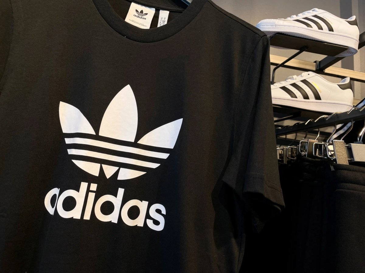 Adidas logo with Yeezy sneakers highlighting the brand's financial struggles - Global Banking & Finance Review