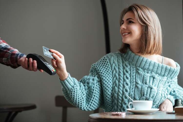 Cheerful young lady in a cafe discussing contactless payments - Global Banking & Finance Review