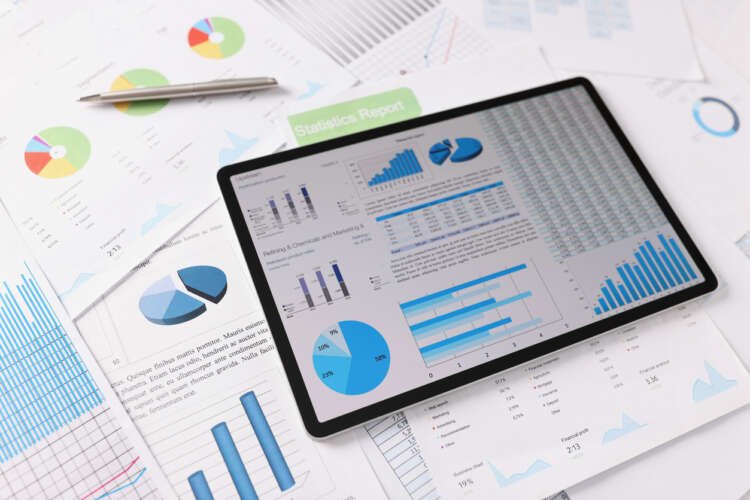 Workplace setting with business papers and tablet displaying AI data insights - Global Banking & Finance Review