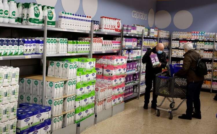 Couple selecting milk in a Barcelona supermarket during product rationing - Global Banking & Finance Review