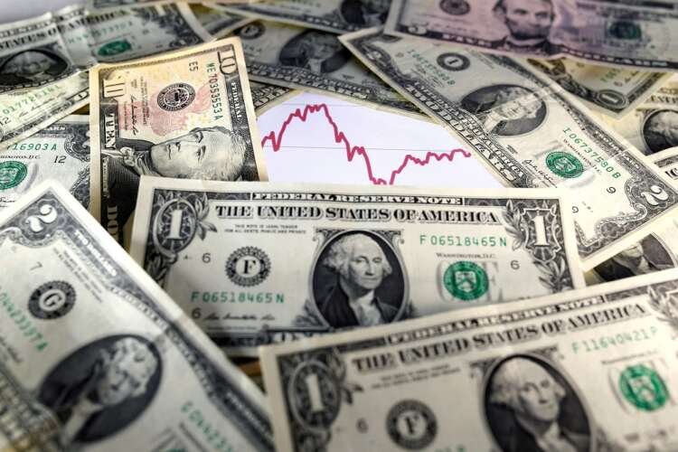 U.S. dollar notes in front of a fluctuating stock graph related to market trends - Global Banking & Finance Review