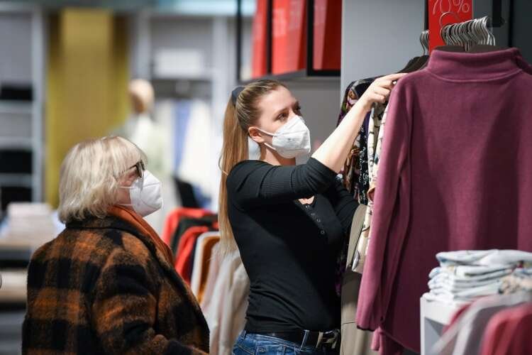A shop assistant helps a customer in a department store after the re-opening of certain businesses in Munich