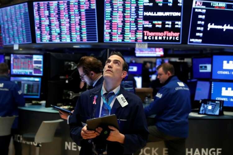 Traders work on the floor of the New York Stock Exchange (NYSE) as the building prepares to close indefinitely due to the coronavirus disease (COVID-19) outbreak in New York
