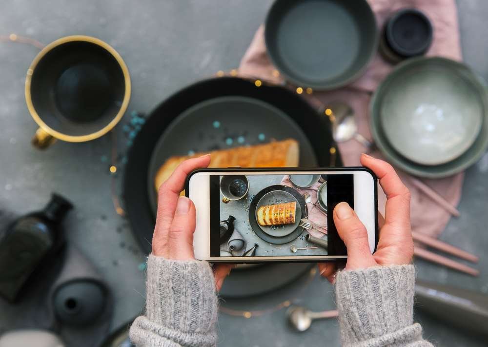 Person using Instagram on a smartphone to create engaging content for monetization - Global Banking & Finance Review