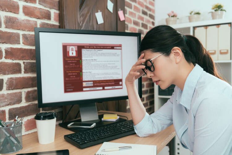 Woman concerned while using a computer, highlighting online fraud risks - Global Banking & Finance Review