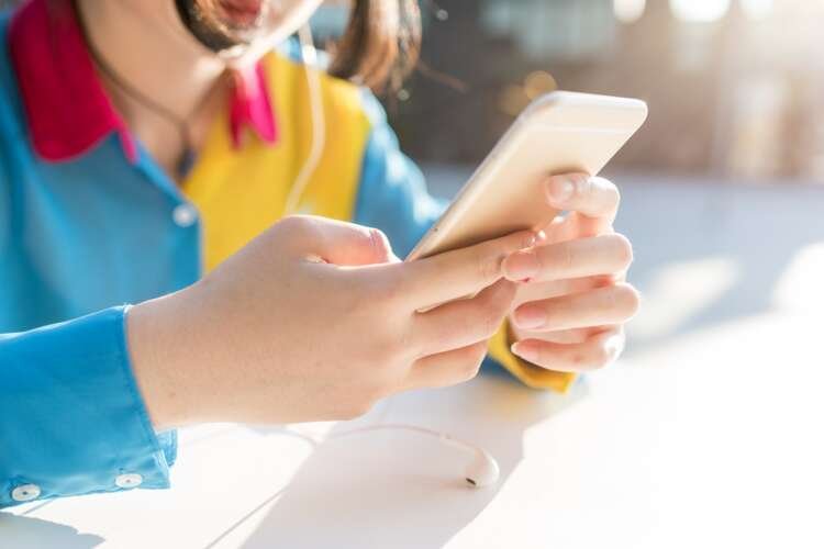 Close-up of a young woman using a smartphone for digital banking innovation - Global Banking & Finance Review