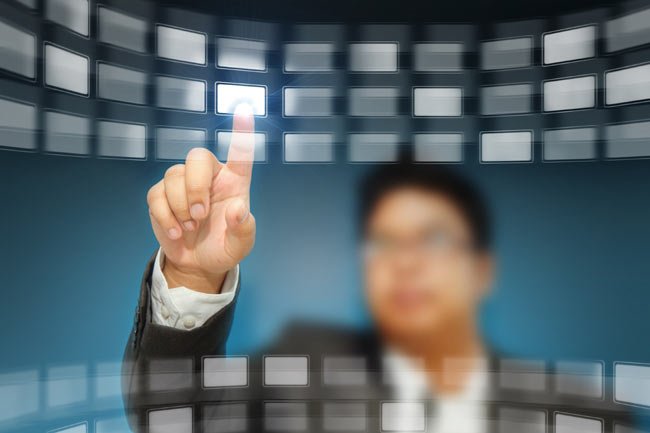 A person interacting with a touch screen, symbolizing compliance in financial services - Global Banking & Finance Review