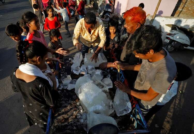 A man distributes ice blocks to residents in Ahmedabad amid extreme heat - Global Banking & Finance Review