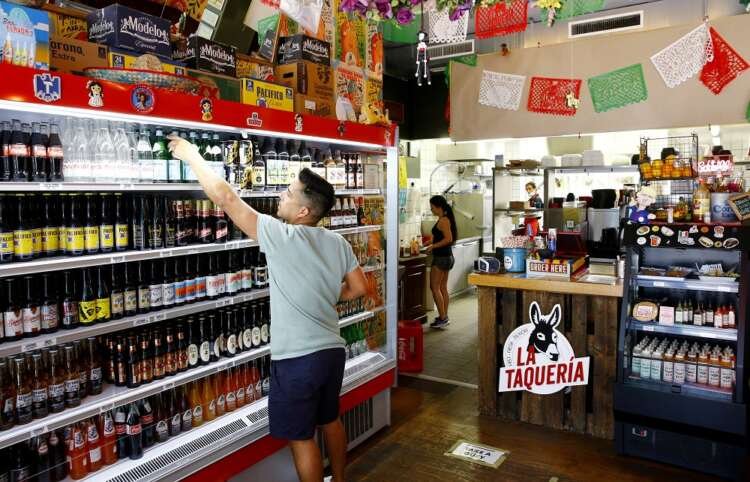 Employee arranging food items in a restaurant, symbolizing Swiss economic recovery - Global Banking & Finance Review