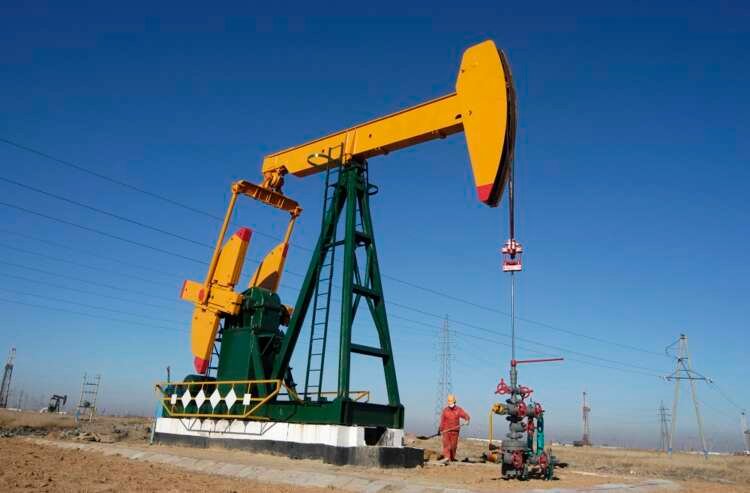 Oil field worker operating a pump jack in China amidst fluctuating oil prices - Global Banking & Finance Review