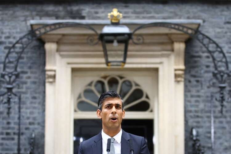 Rishi Sunak standing outside Downing Street, pledging to address UK economic crisis - Global Banking & Finance Review