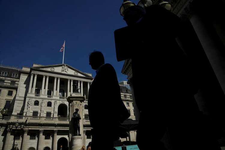 Silhouetted workers walk past the Bank of England, reflecting economic shifts - Global Banking & Finance Review