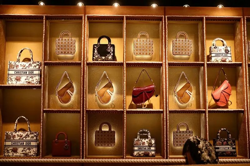 Image for Luxury labels bulk up on lower-priced goods to appeal to middle-class shoppers