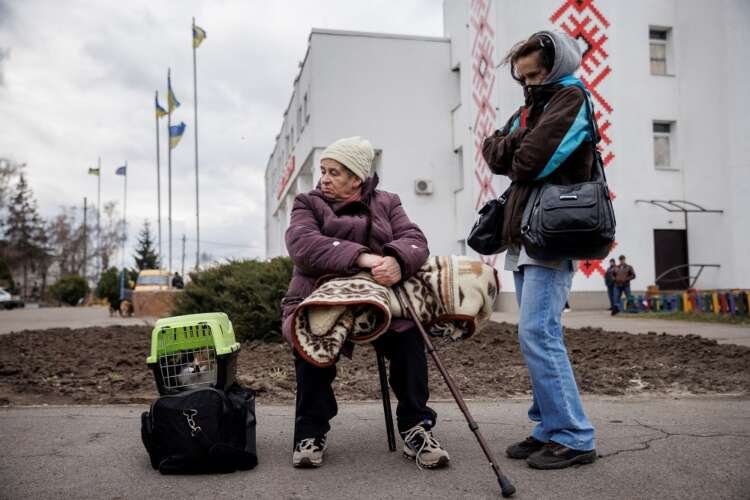 People wait to be evacuated from the heavily shelled town of Derhachi outside Kharkiv