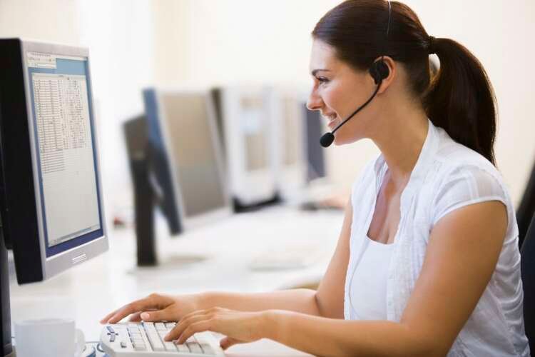 Woman wearing headset in computer room smiling