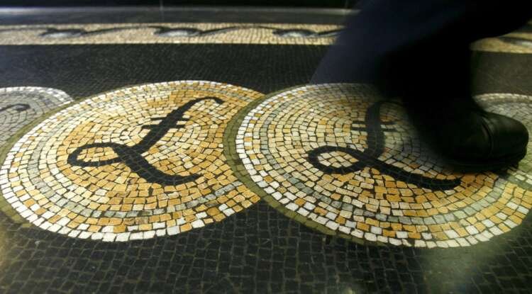 Employee walking over a mosaic of pound sterling symbols at the Bank of England - Global Banking & Finance Review