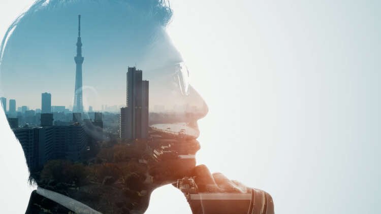 Silhouette of a contemplative man overlaid with a cityscape, symbolizing climate-conscious business leadership - Global Banking & Finance Review