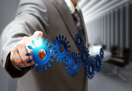 Businessman pointing at gears, symbolizing PCI DSS compliance in finance - Global Banking & Finance Review