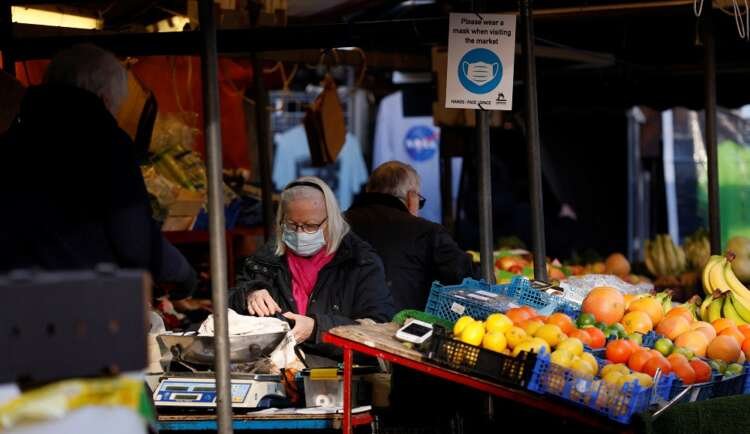 Woman shopping in Cambridge Market Square amid UK cost-of-living crisis - Global Banking & Finance Review