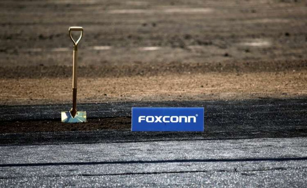 Foxconn logo at groundbreaking ceremony with shovel, highlighting challenges in electronics amid COVID and inflation - Global Banking & Finance Review