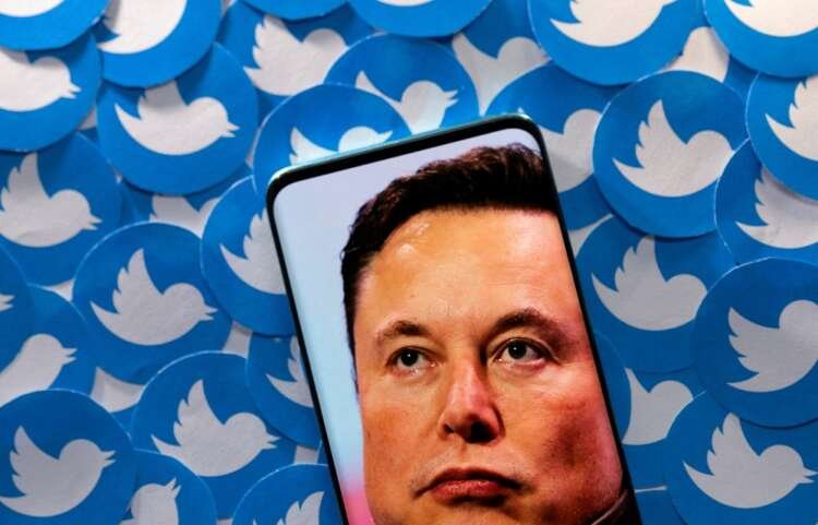 Elon Musk on smartphone with Twitter logos, reflecting on the Twitter deal controversy - Global Banking & Finance Review