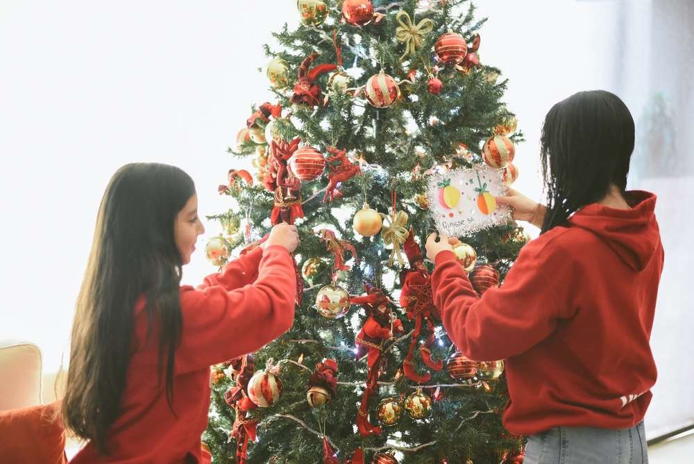 Family gathered around a Christmas dinner table, discussing tips to avoid arguments - Global Banking & Finance Review