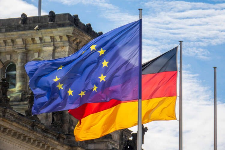 EU and German flags waving in front of the Reichstag, symbolizing Brexit's impact on Germany - Global Banking & Finance Review