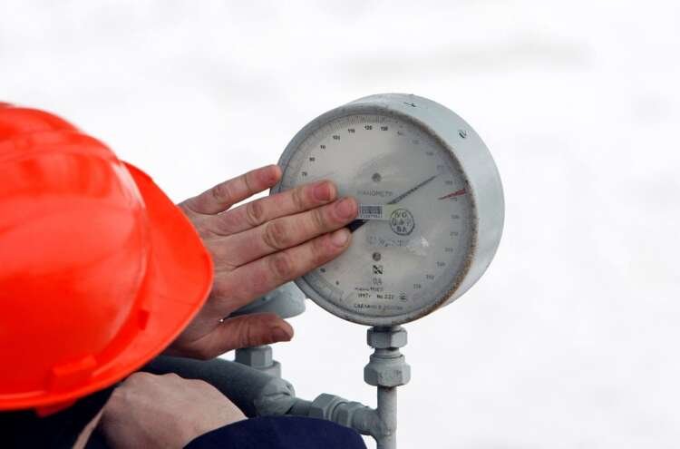 Technician inspecting gas pressure gauge at Gazprom's Sudzha station - Global Banking & Finance Review