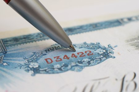 Pen resting on stock market shares representing Islamic trading account - Global Banking & Finance Review