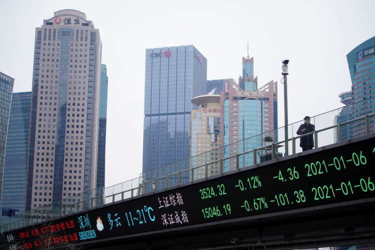Man in a mask on an overpass with stock indexes display in Shanghai - Global Banking & Finance Review