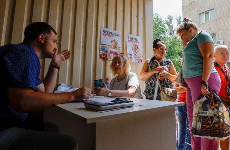 Image for Beneath a portrait of Putin, some Ukrainians embrace Russian passports