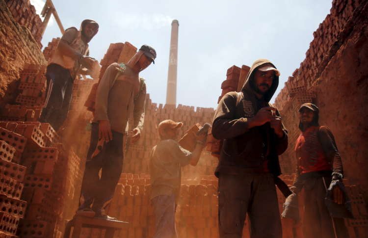 Labourers work at a traditional bricks factory in Arab Mesad district of Helwan, northeast of Cairo