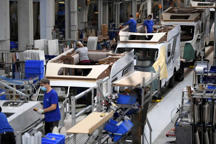 Workers assembling campers in a factory, highlighting Euro zone economic activity - Global Banking & Finance Review