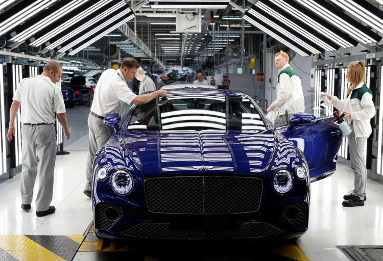 Workers inspect a Bentley Continental GT at the luxury automaker’s manufacturing facility in Crewe