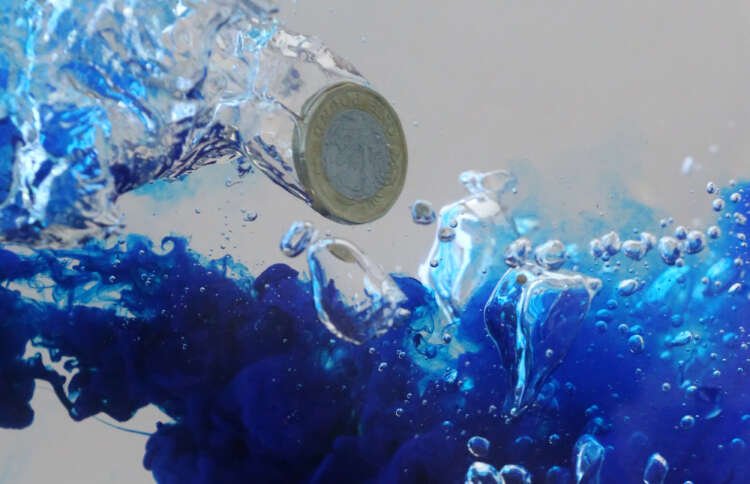 Illustration of UK pound coin sinking in water, symbolizing sterling's decline against euro - Global Banking & Finance Review