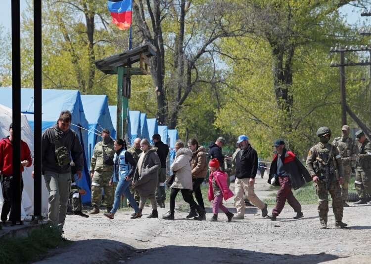Civilians who left the area near Azovstal steel plant in Mariupol walk at a temporary accommodation centre in Bezimenne